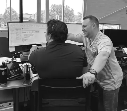 Two employees looking at computer screen